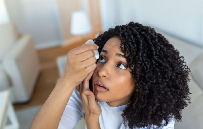 A woman putting presbyopia eye drops into her eyes.