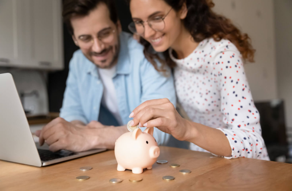 Young millennial couple putting more into their piggy bank because of the affordability of Telehealth eye exams.