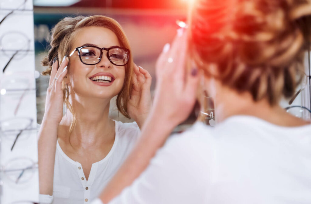 "A young woman with a round face trying on a new pair of glasses at an optical shop."