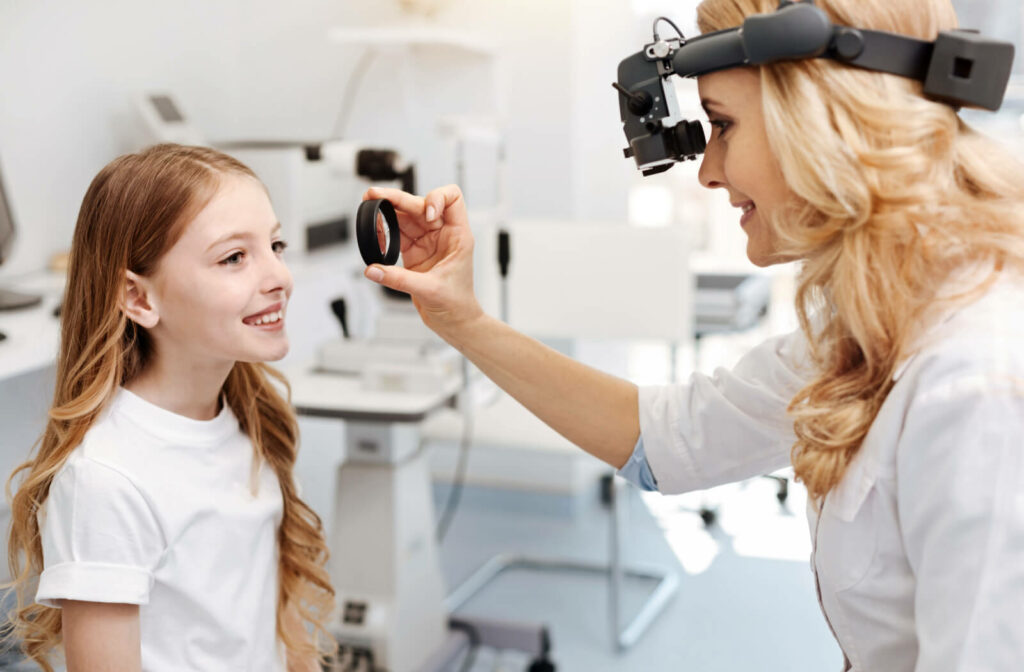 an eye doctor performs an eye exam on a young girl to determine if she has childhood myopia